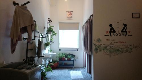 a bathroom with a sink and a window and plants at Stay With Me Capsules Hostel in Malacca