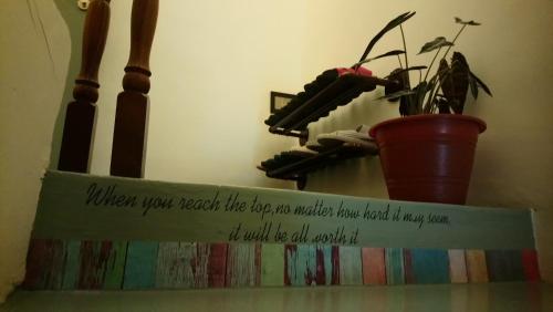 a sign on top of a shelf with a potted plant at Stay With Me Capsules Hostel in Malacca