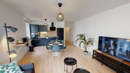 un salon avec une table et des chaises et une cuisine dans l'établissement Hallesgare 1 free parking, à Strasbourg