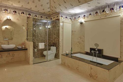 a bathroom with a tub and a toilet and a sink at Clarks Safari Ranthambore in Khilchipur
