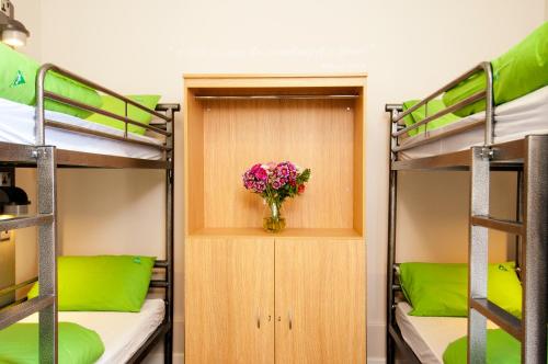 a room with two bunk beds and a vase with flowers at YHA Stratford-Upon-Avon in Stratford-upon-Avon