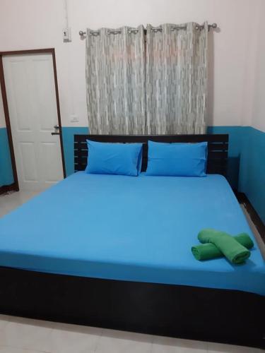 a blue bed with blue sheets and blue pillows at เพชรสุดาเฮ้าส์ in Phetchaburi