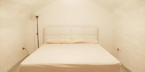 a white bed in a white room with at Duplex Itri in Itri