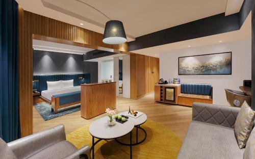 a hotel room with a bed and a living room at Novotel Mumbai Juhu Beach in Mumbai