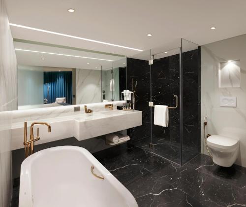 a bathroom with a sink and a toilet and a shower at Novotel Mumbai Juhu Beach in Mumbai