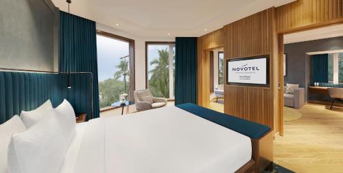a bedroom with a large bed in a room at Novotel Mumbai Juhu Beach in Mumbai
