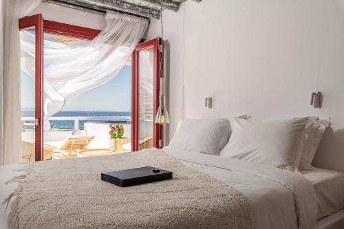 a bedroom with a bed and a window at The TownHouse Mykonos in Mýkonos City