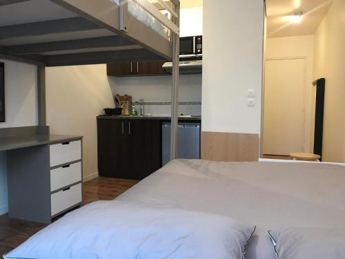 a bedroom with a loft bed and a kitchen at Studio 22m2 RER Val d’Europe à 150m /Disney-Paris in Montévrain