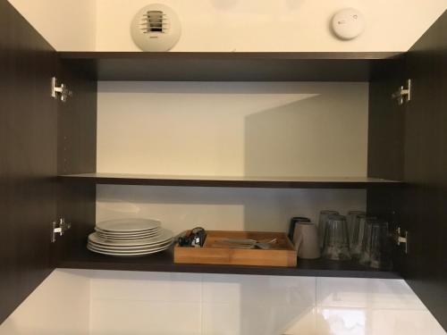 a kitchen with a shelf with plates on it at Studio 22m2 RER Val d’Europe à 150m /Disney-Paris in Montévrain