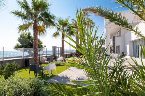 Blick auf den Strand von einem Haus mit Palmen in der Unterkunft Santantonioresort in Riposto