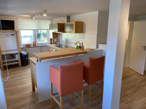 a kitchen with a counter and two bar chairs at Quartier am Haff in Ueckermünde