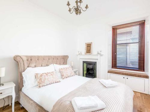 a white bedroom with a bed and a fireplace at Casa Fresa - Ferry House in Broughty Ferry