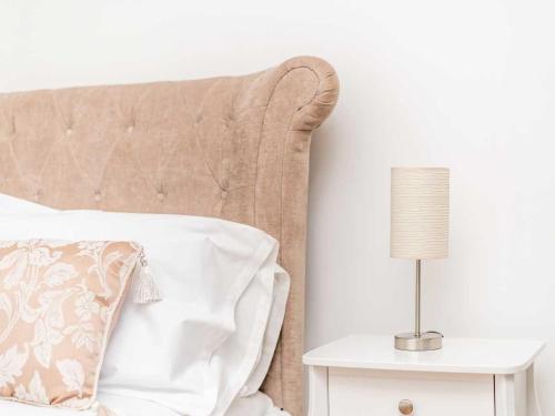 a bed with a pillow and a lamp on a side table at Casa Fresa - Ferry House in Broughty Ferry
