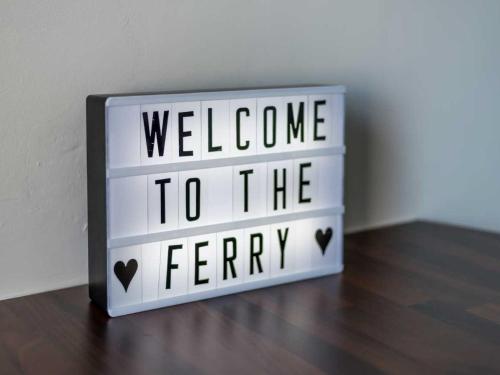 a welcome to the ferry sign sitting on a wooden floor at Casa Fresa - Ferry House in Broughty Ferry