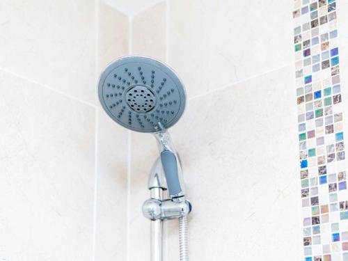 a blue shower head in a white bathroom at Casa Fresa - Ferry House in Broughty Ferry