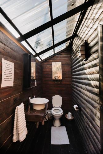 a bathroom with a toilet and a sink and a tub at Umzumbe Surf House in Umzumbe