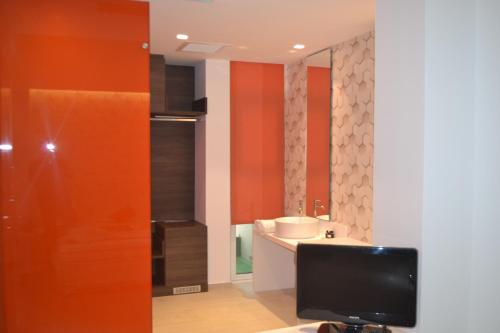 a room with a television and a bathroom at Amazon Hotel in Athens