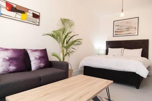 sala de estar con sofá y cama en The Square Holiday Apartments en Ciudad del Cabo