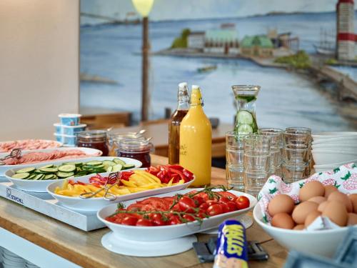 a table with plates of food and eggs on it at Göteborg Hostel in Gothenburg