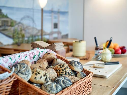 a basket of different types of bread on a table at Göteborg Hostel in Gothenburg