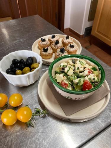 a table with a bowl of salad and plates of food at Csodaszarvas Vendégházak in Rábahidvég