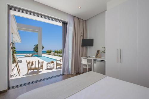 a bedroom with a bed and a view of the ocean at Eros Cyprus in Ayia Napa