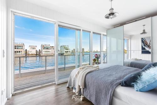 a bedroom with a large window with a view of the water at Stella Maris in Olpenitz