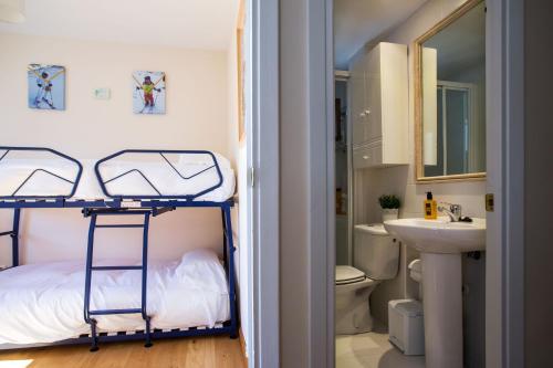 福米加尔Foratata By PIRINEOS360 Formigal - 3 dormitorios Y 2 baños的一间卧室配有双层床和水槽