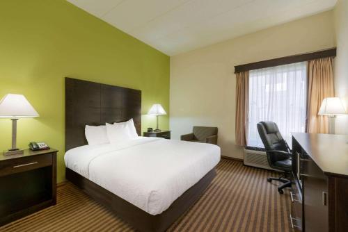 a hotel room with a bed and a desk at La Quinta by Wyndham Columbus - Grove City in Grove City