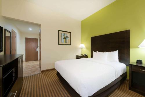a hotel room with a large bed and a television at La Quinta by Wyndham Columbus - Grove City in Grove City