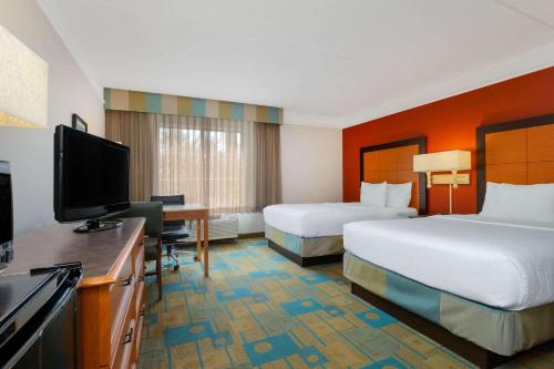 um quarto de hotel com duas camas e uma televisão de ecrã plano em La Quinta by Wyndham Lakeland West em Lakeland
