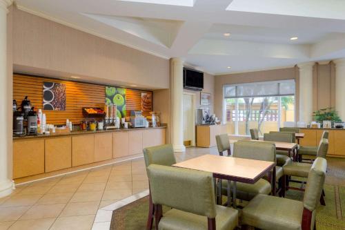 a restaurant with a table and chairs and a counter at La Quinta by Wyndham Lakeland West in Lakeland