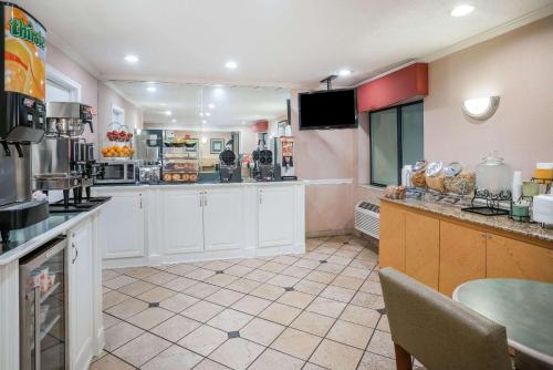 a large kitchen with white cabinets and a table at La Quinta by Wyndham Nashville Franklin in Franklin