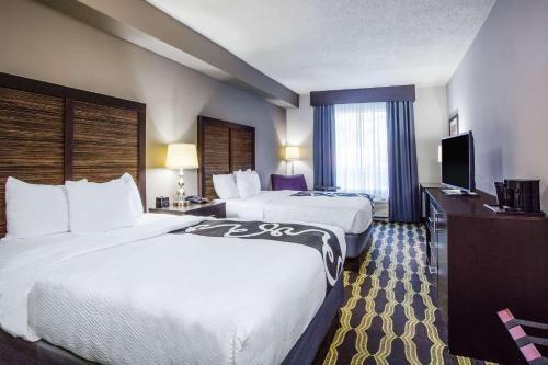 a hotel room with two beds and a flat screen tv at La Quinta by Wyndham Lynchburg at Liberty Univ. in Lynchburg