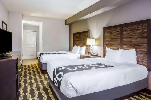 a hotel room with two beds and a flat screen tv at La Quinta by Wyndham Lynchburg at Liberty Univ. in Lynchburg