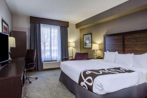 a hotel room with a large bed and a television at La Quinta by Wyndham Lynchburg at Liberty Univ. in Lynchburg