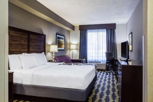 a hotel room with a large bed and a television at La Quinta by Wyndham Lynchburg at Liberty Univ. in Lynchburg