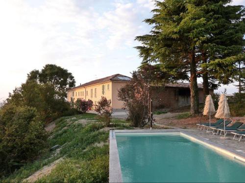 a swimming pool in front of a yellow building at Allegro Holiday in Nizza Monferrato