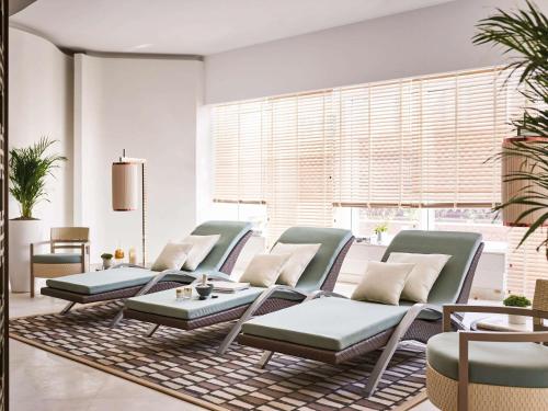 a group of chairs and tables in a room at Pullman Doha West Bay in Doha