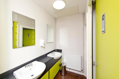 a bathroom with two sinks and a mirror at YHA Manorbier in Tenby