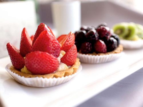 two pies with strawberries and blackberries on a shelf at Swissotel Quito in Quito