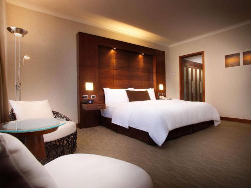 a hotel room with a large bed and a large mirror at Swissotel Quito in Quito