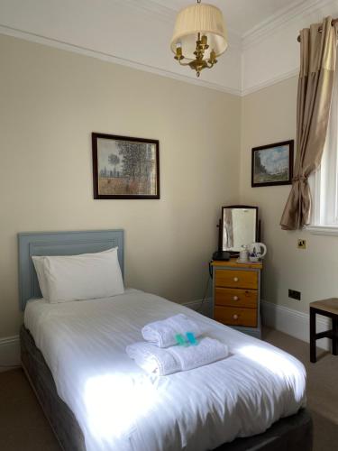 a bedroom with a bed with two towels on it at Fieldways in Trowbridge