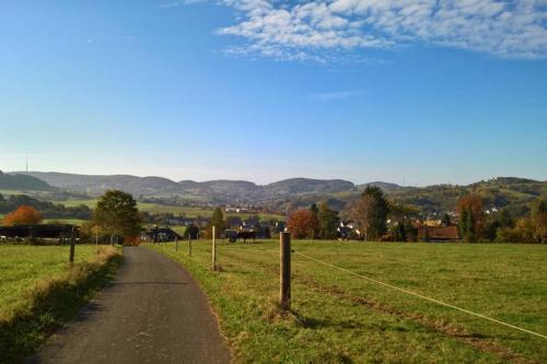 a dirt road in a field with a fence at Entspannen im Grünen, Ferienwohnung mit eigenem Garten in Keilberg