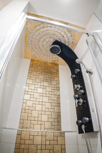 a bathroom with a shower with a tile floor at AH Luxury Galerka in Košice