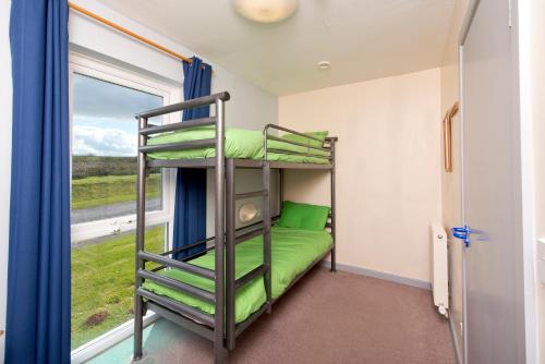 a bunk bed in a room with a window at YHA Manorbier in Tenby