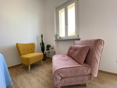 a living room with a couch and a yellow chair at Allegro Holiday in Nizza Monferrato