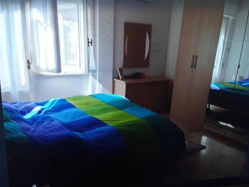 um quarto com uma cama com um cobertor colorido em Appartamento a 5 minuti dal mare- apartment very close to the sea em Pescara