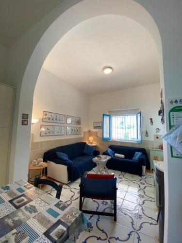 a living room with a blue couch and a table at Villa Lucky in Punta Prosciutto