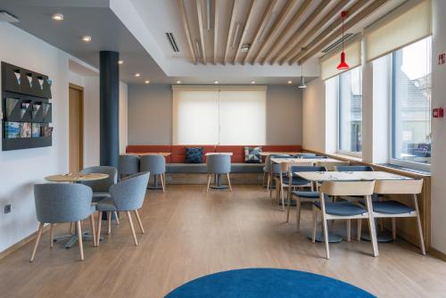 a restaurant with tables and chairs and a couch at Holiday Inn Express - Ljubljana by IHG in Ljubljana